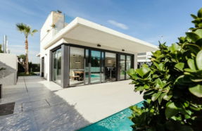 white and grey concrete building near swimming pool under clear sky during daytime